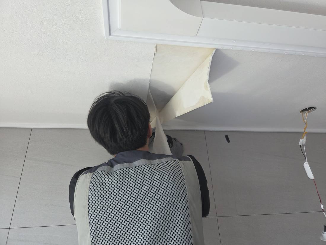 천장 스킨(도배지) 절개 부위를 젖혀 안쪽 누수 흔적을 확인하는 모습